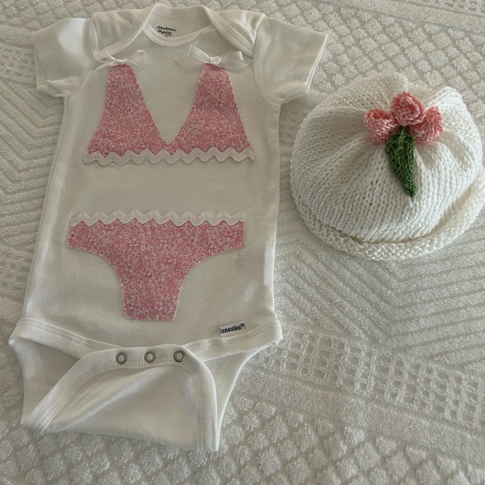 3 to 6 months bikini onesie and hand knitted rosebud hat.